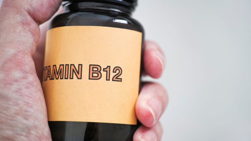 Person holding a bottle of vitamin B12